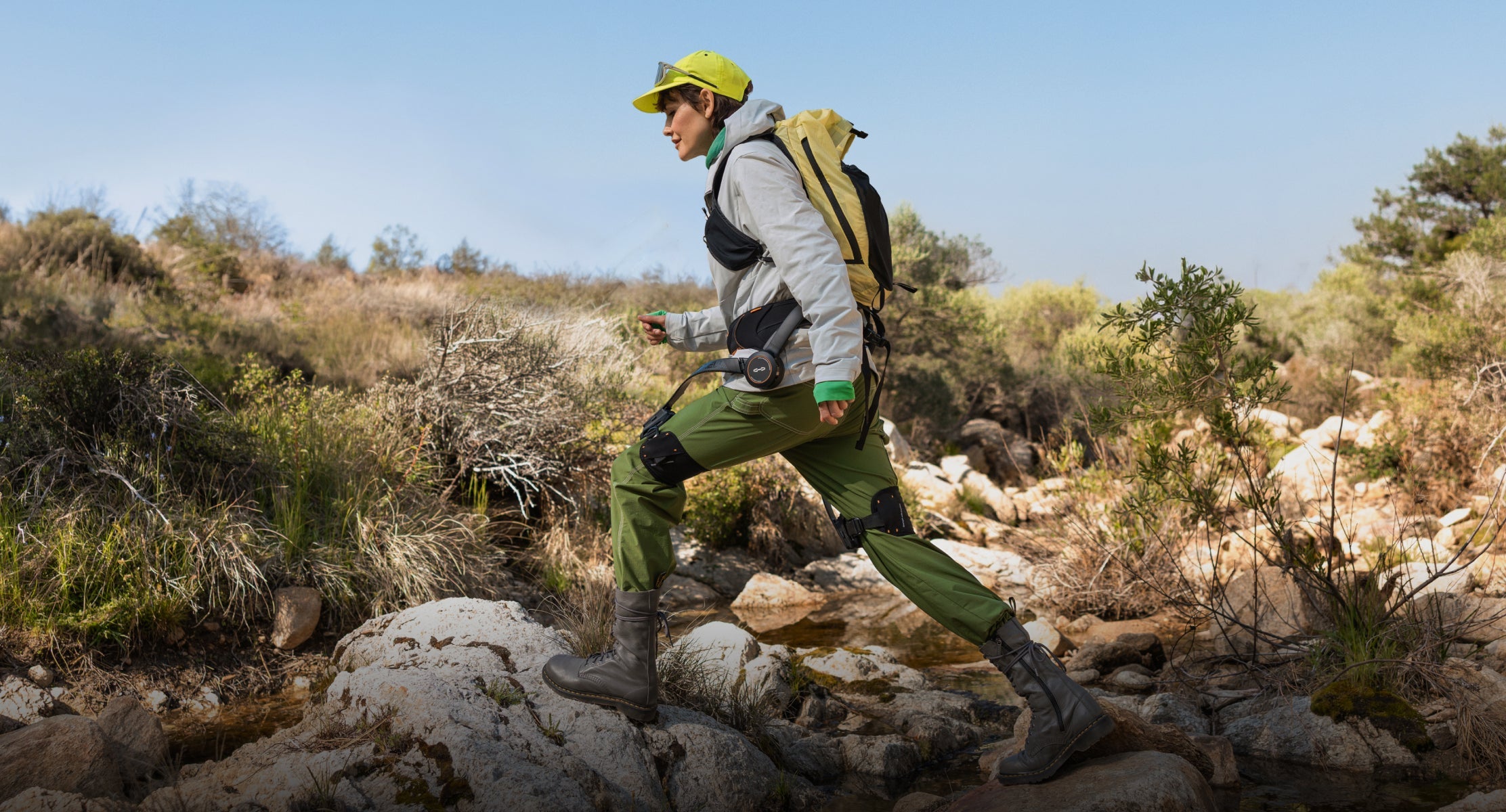 Person hiking through a rocky landscape with greenery