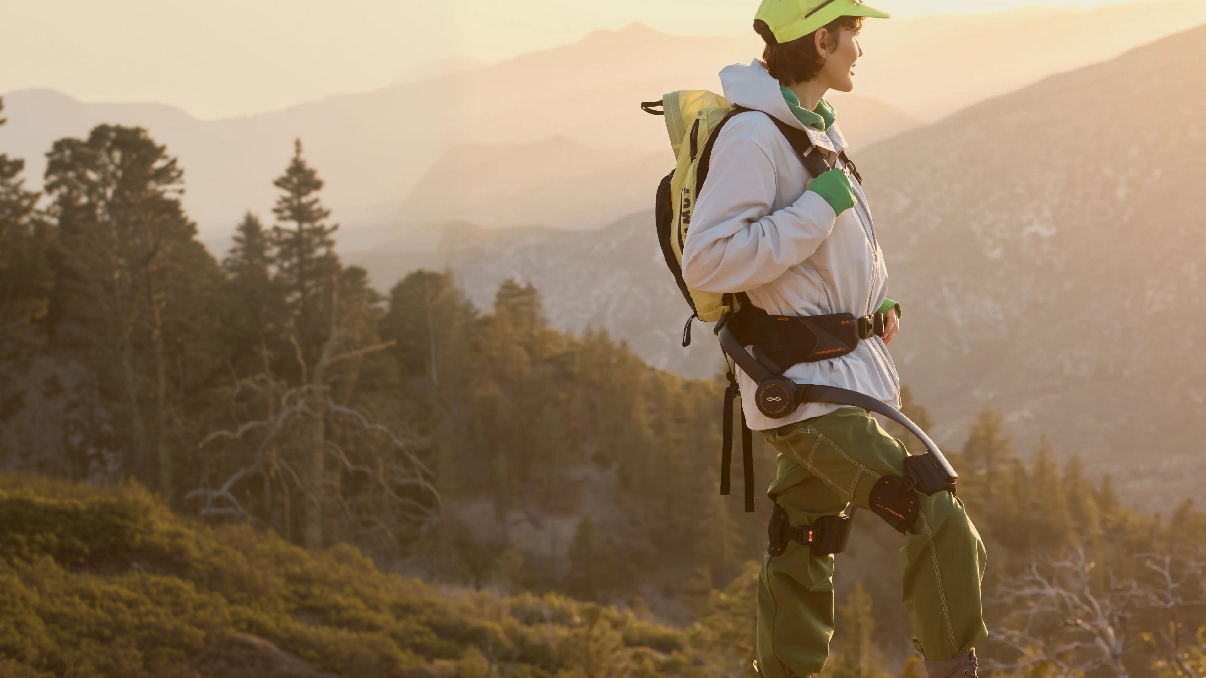 Hiker wearing a genuine Hypershell X Series S exoskeleton on a sunlit hillside